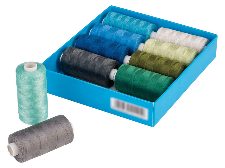 Een doos met garen in verschillende kleuren, waaronder grijs, groen en blauw.