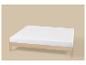 Houten bedframe met wit matras op een beige achtergrond