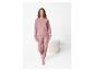 Vrouw in roze loungewear set met poef