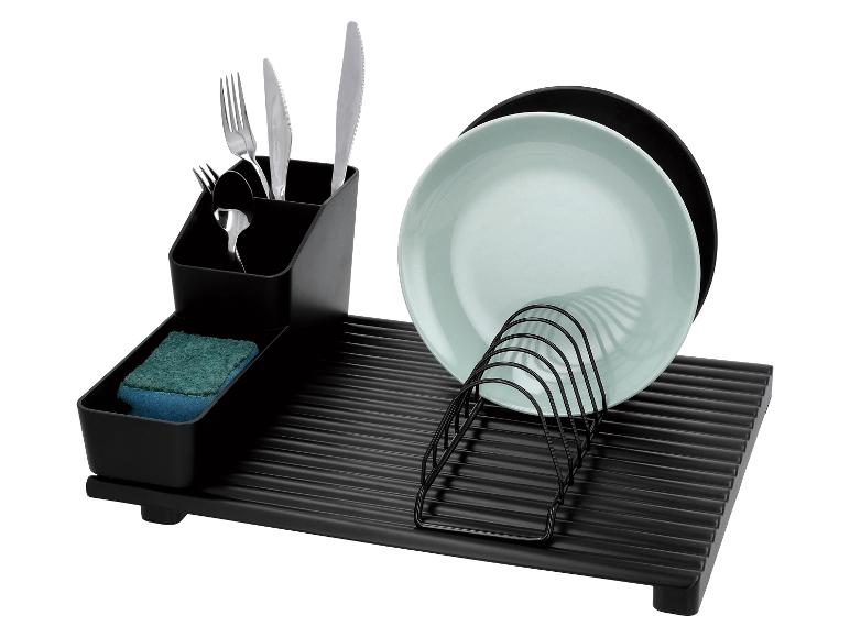 Zwart afdruiprek met bestek, spons en borden.