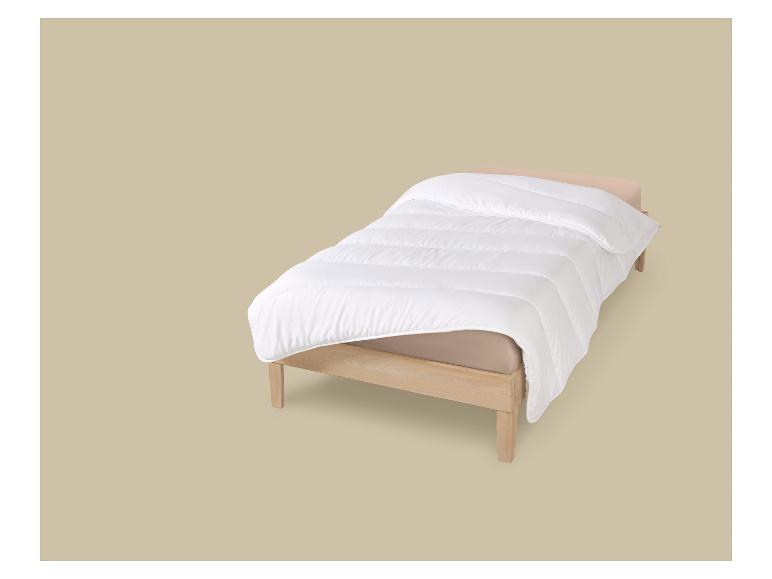 Eenpersoonsbed met wit dekbed en beige hoeslaken op een beige achtergrond