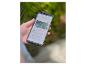 Hand houdt smartphone vast met smart home-app voor tuin camerabediening.
