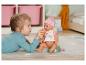 Een meisje geeft een Baby Born pop een flesje.