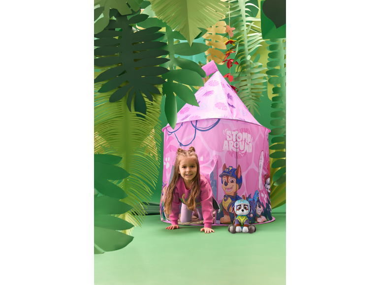 Meisje speelt in roze speeltent in jungle-thema kamer met knuffel.