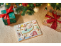 Houten boerderijdierenpuzzel met kerstcadeaus en decoraties op een deken.