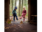Twee jonge kinderen in warme buitenkleding en laarzen spelen in een plas in het bos.