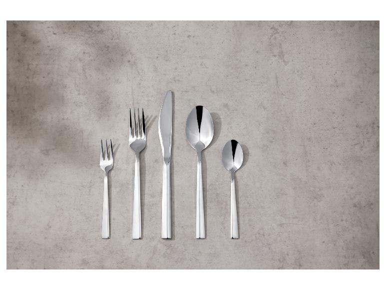 Set glanzend zilveren bestek op een betonnen achtergrond.