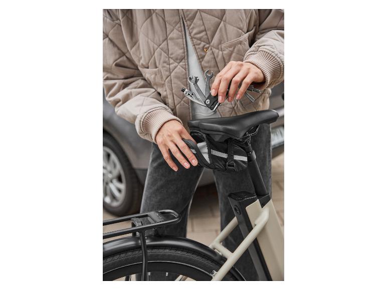 Persoon met een fiets-multitool en een fietszadeltas.