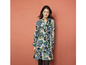 Een vrouw draagt een lange, blauwe jurk met bloemenprint.