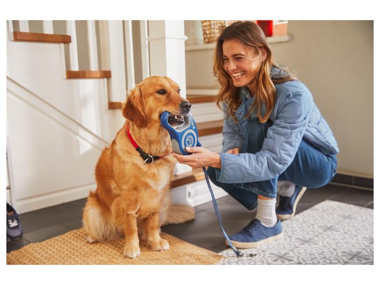 Een vrouw en haar hond met een blauwe riem.