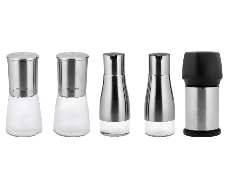 Vijf zout- en pepermolens van roestvrij staal en glas.