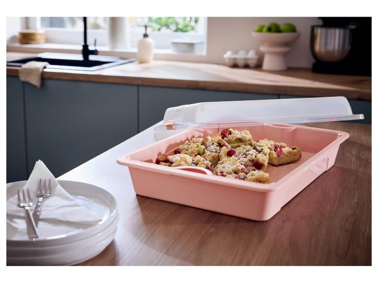 Roze taartdoos met rabarbercrumble in een moderne keuken.