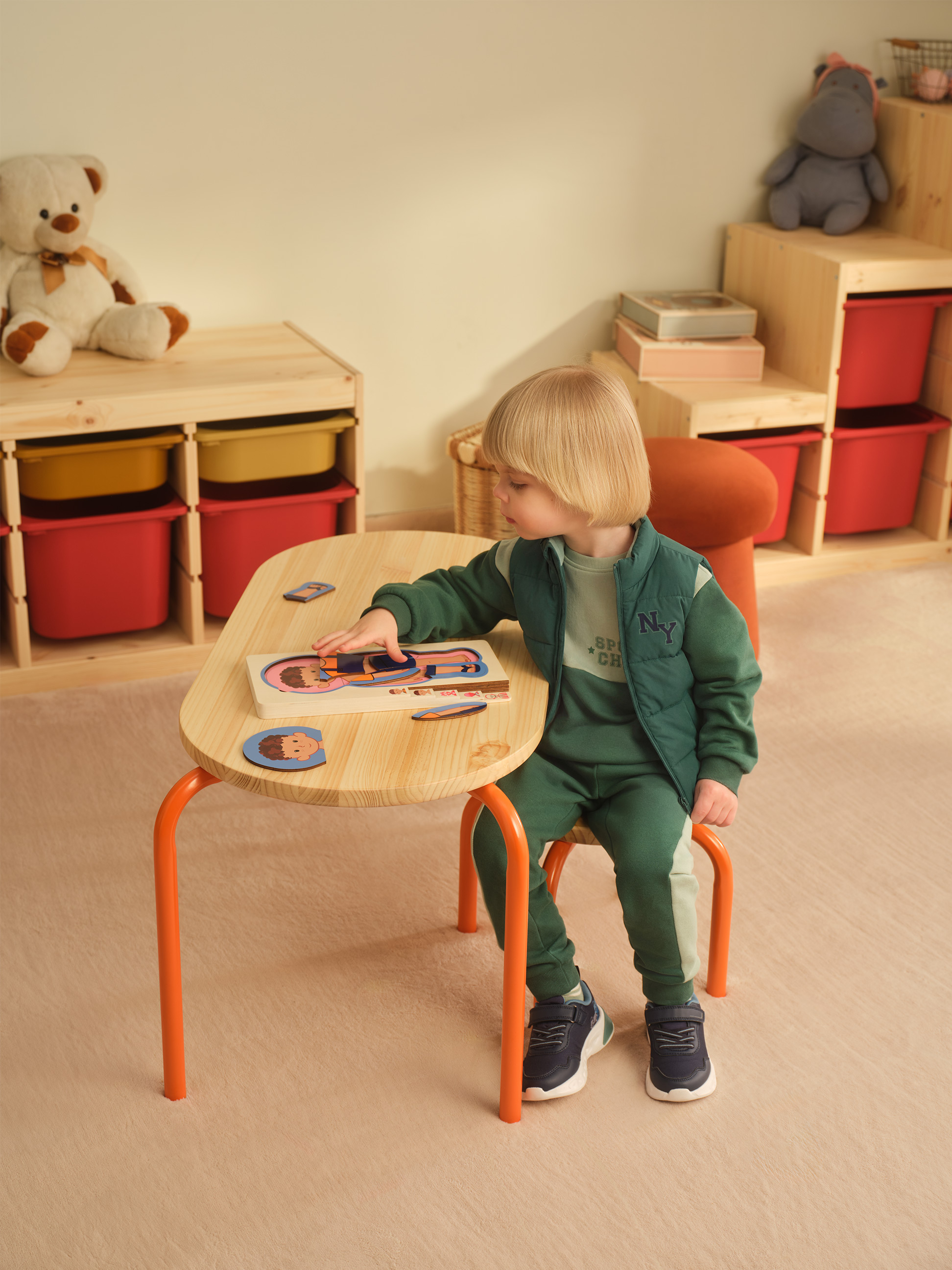 Kind speelt met houten puzzel aan een activiteitentafel in een kinderkamer.