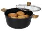 Zwarte kookpot met houten handvatten, glazen deksel en aardappelen