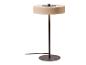 Moderne tafellamp met ronde beige kap en donkere metalen voet.