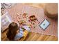 Kind bouwt LEGO-set op de vloer met een tablet die instructies toont.