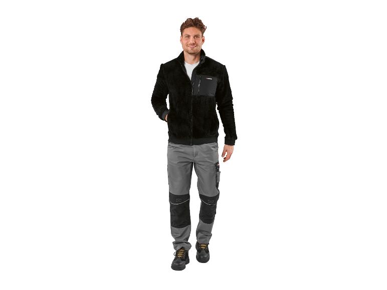 Man in zwarte fleece jas en grijze werkbroek