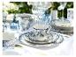 Elegant blauw-wit bloemendiner servies op een wit tafelkleed, met gouden bestek.