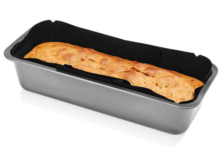 Een gebakken cake in een grijze bakvorm.