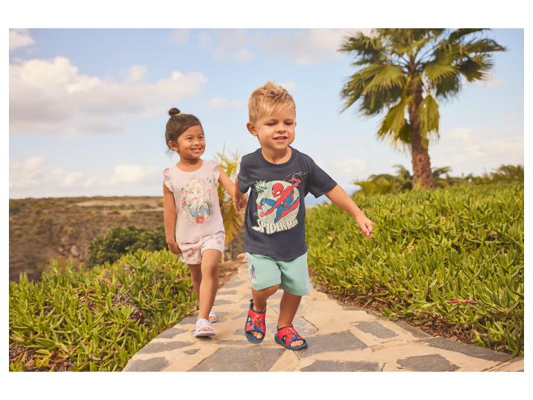 Twee kinderen lopen op een pad, het meisje draagt een top met prinsessenprint, de jongen een T-shirt met superheldenprint.