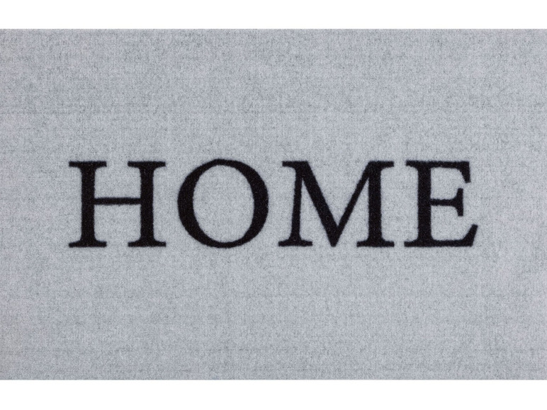 Een grijze deurmat met de tekst 'HOME' erop.