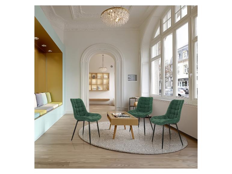 Groene gestoffeerde stoelen in een wachtruimte met een houten salontafel en ramen.