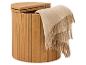 Lichte houten ronde wasmand met open deksel en beige wollen plaid