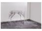 Aluminium klaptafel met verstelbare poten in een witte kamer met donkere vloer.