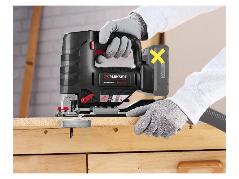 Gehandschoende handen gebruiken een draadloze decoupeerzaag om hout te zagen.