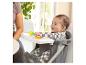 Blauwe baby zit in een kinderstoel met een dienblad vol kleurrijk speelgoed.