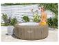 Vrouw in gele badkleding zittend op een opblaasbare hot tub in een tuin.