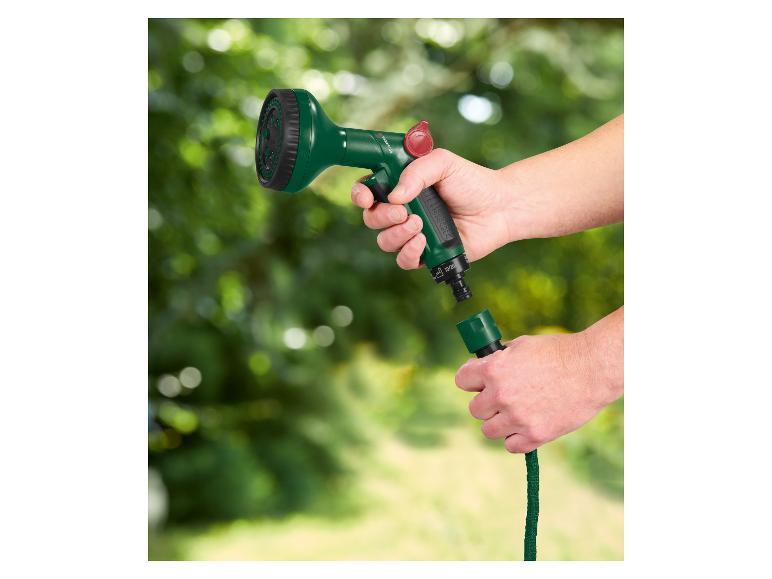 Handen verbinden een groen tuinslangmondstuk met een groene slang.