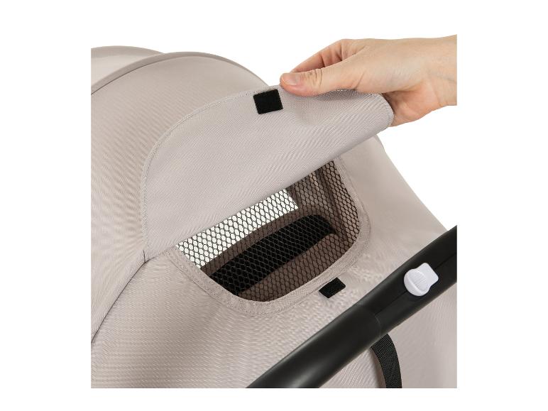 Hand tilt de ventilatieraamklep op een beige kinderwagenkap op.