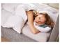 Vrouw slaapt vredig in bed met wit dekbed en kussen, groen kussen met tekst.