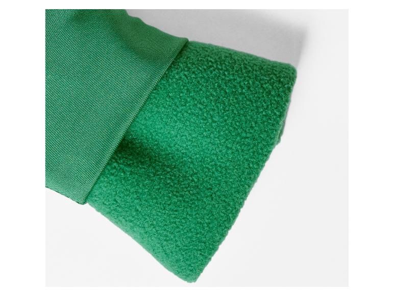 Detail van de mouw van een groen jasje met dubbel gelaagd materiaal.