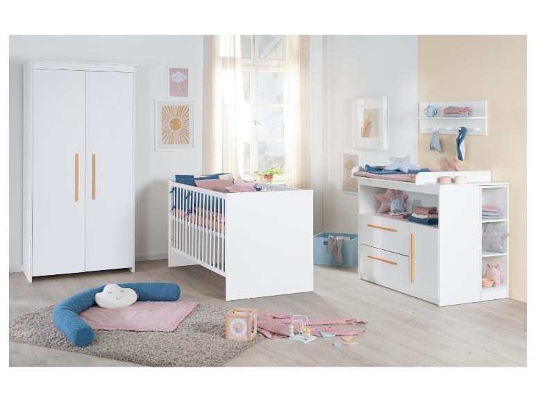 Witte babykamer met ledikant, kledingkast en commode, met houten accenten.