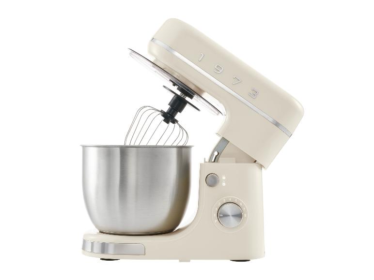 Een crèmekleurige vintage keukenmachine met een roestvrijstalen kom.