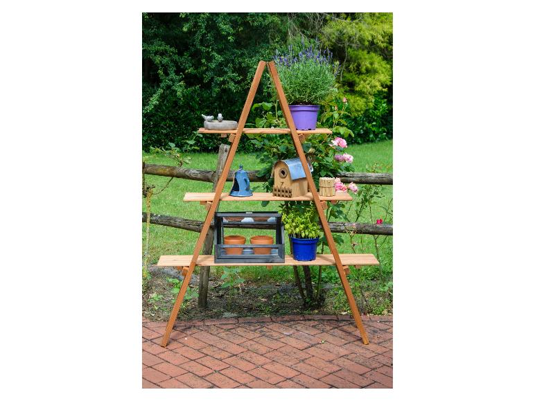 Houten plantenrek met diverse potplanten en tuindecoraties buiten.
