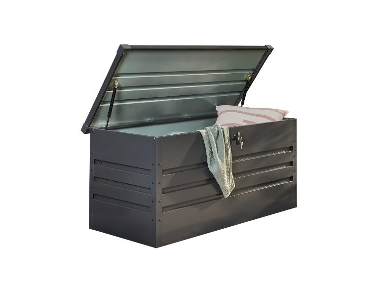 Donkergrijze buitenopbergbox met open deksel, met een kussen en een deken.