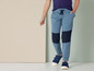 Blauwe joggingbroek met kniebeschermers en blauwe sneakers.