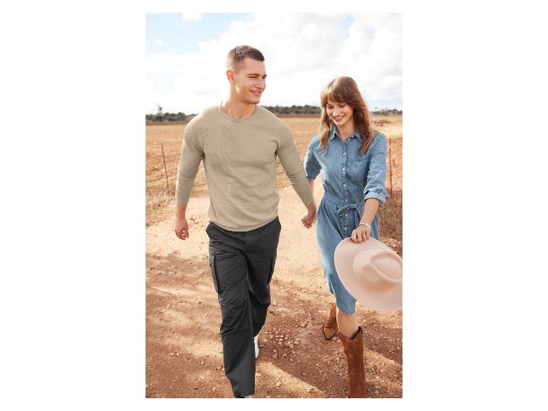 Een man en vrouw dragen casual kleding, waaronder een denimjurk en een beige trui.