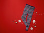 Een paar blauwe leggings met een kerstpatroon op een rode achtergrond