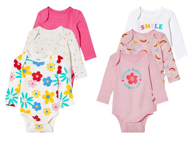Baby onesies met bloemen, regenbogen en 'Smile' print.