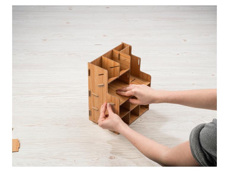 Een houten organizer met vakken wordt in elkaar gezet.