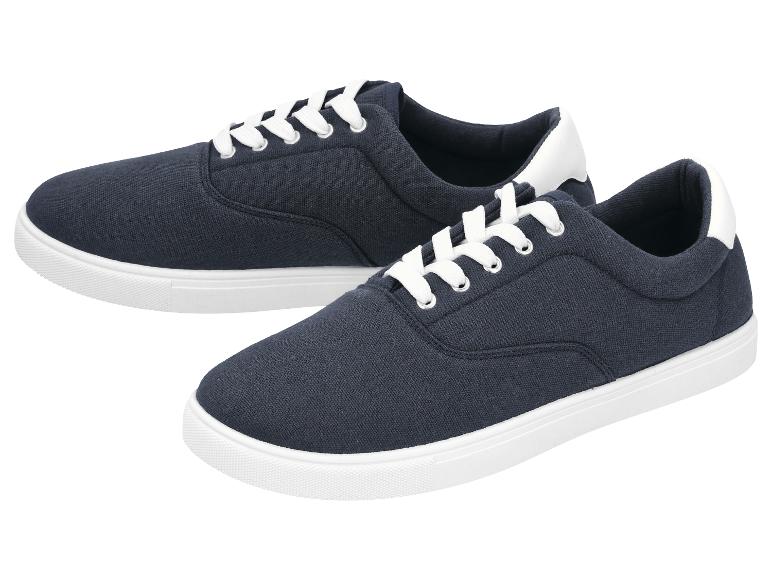 Een paar donkerblauwe sneakers met witte veters en zolen.