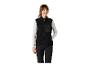 Vrouw in zwarte fleece bodywarmer met oranje ritsen en zwarte broek