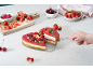 Hartvormige cheesecake met bessen, geserveerd met aardbeien, frambozen en kersen.