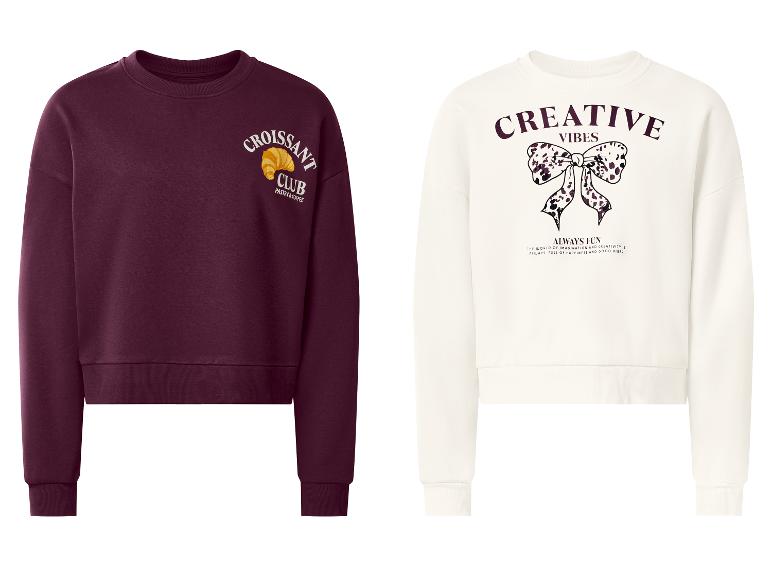 Twee sweatshirts: een bordeauxrode met 'Croissant Club' en een witte met 'Creative Vibes'.