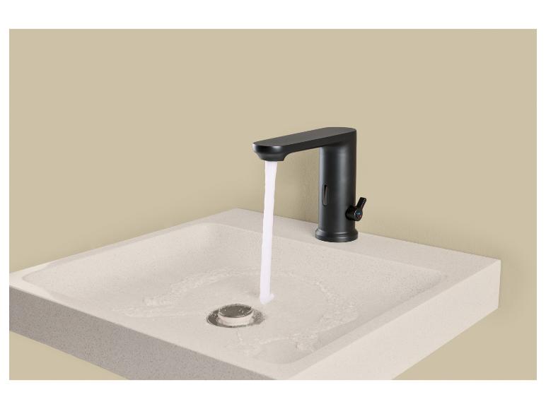 Zwarte kraan met stromend water boven een lichte wastafel.