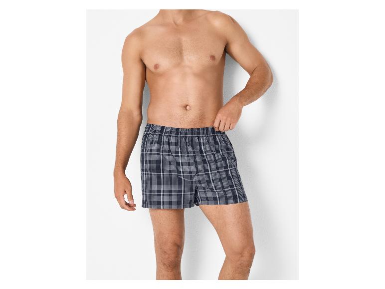 Man in donkerblauwe geruite boxershort.